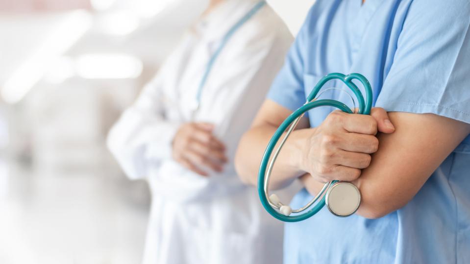 two doctors stand with arms folded