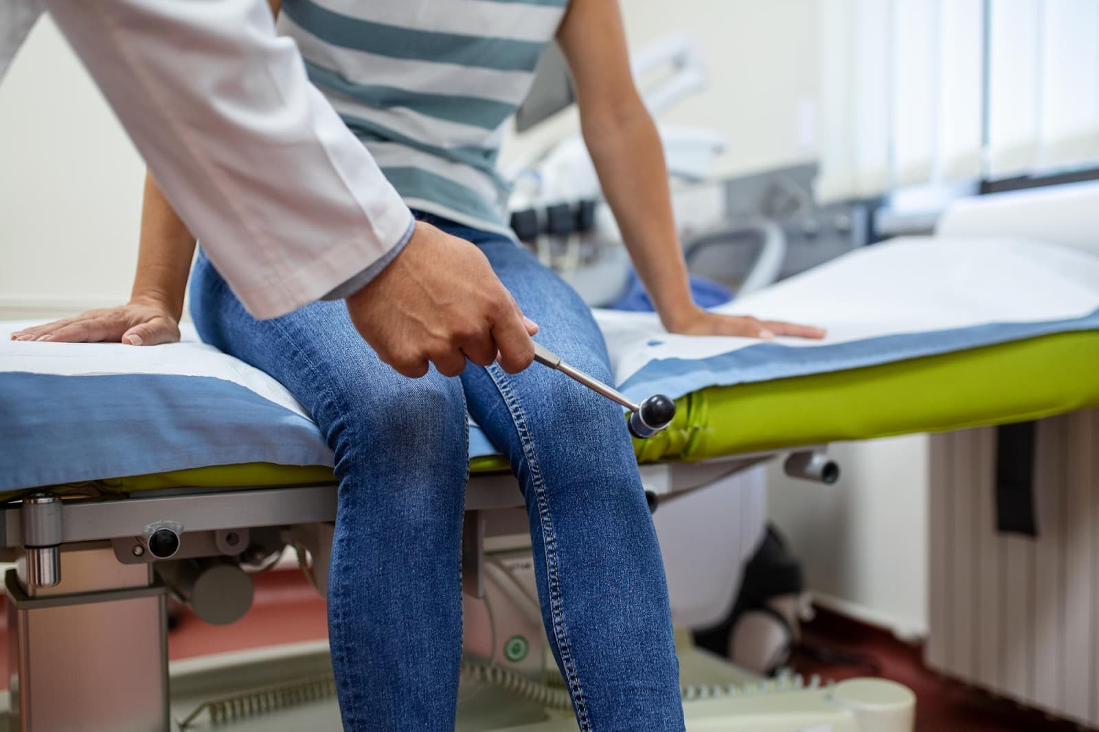 Doctor knocking with a hammer on a patient's knee