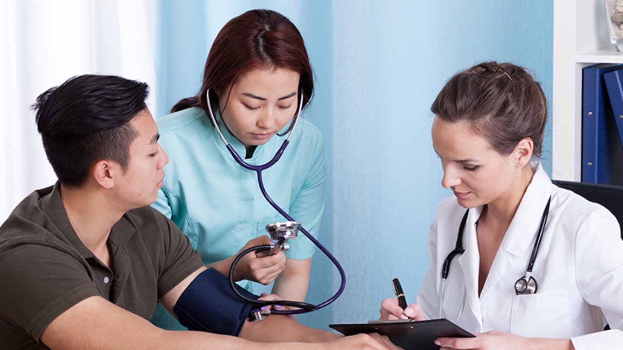 Doctor's assistant taking pulse of patient