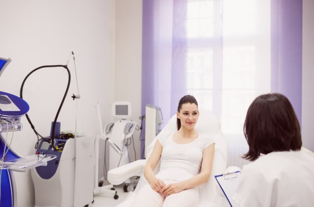 A pregnant woman sitting across from her doctor in a clinic