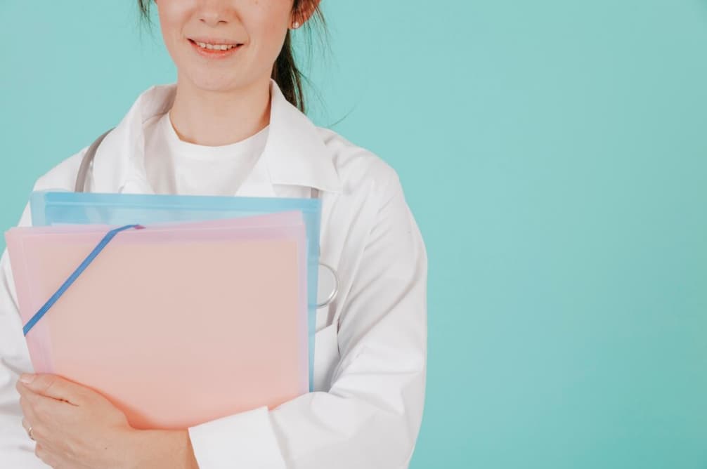 A smiling healthcare professional holding a clipboard