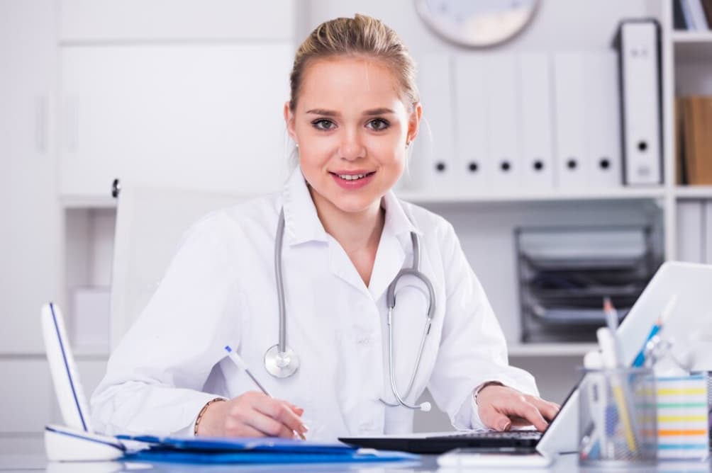 A smiling young female doctor working at her desk