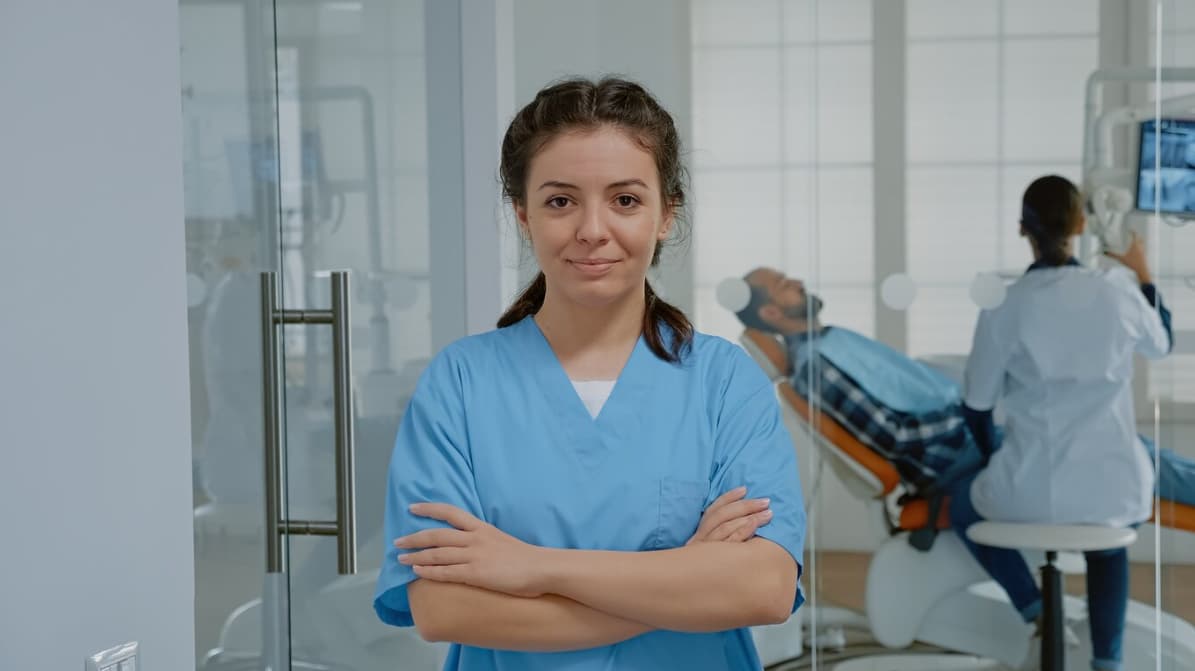 A female healthcare professional stands confidently in a clinic